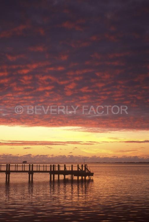 Island Sunsets;manihi;french polynesia;Island;sunset;sky;clouds;yellow;pink;sillouettes;colorful;reflection;ocean;huts